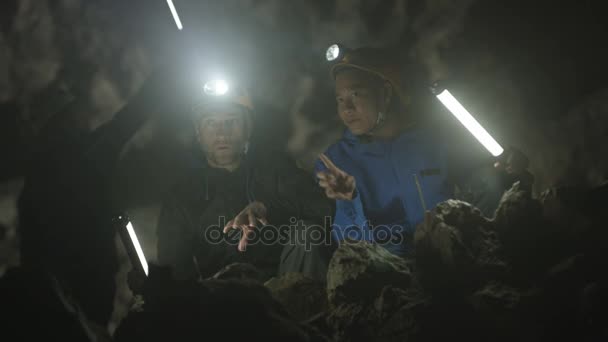 Spelunkers Explorando Caverna Subterrânea Discutindo Formação Rocha — Vídeo de Stock