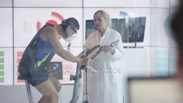 Sport Scientist White Coat Assessing Fitness Man Exercise Bike — Stock Video