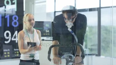 test ve spor bilim adamı tarafından izlenen egzersiz bisikleti üzerinde 4 k Erkek atlet