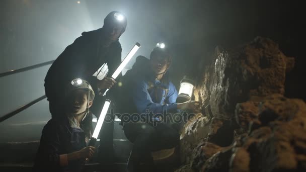 Potholers Exploring Cave System Shafts Light Penetrating Dark — Stock Video
