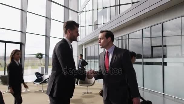で握手ビジネスマンは大規模な近代的なオフィスビルのロビー — ストック動画