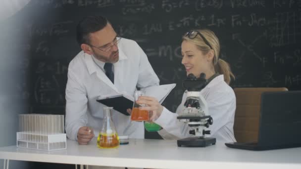 科学家在实验室写作化学和黑板上的数学公式中工作 — 图库视频影像