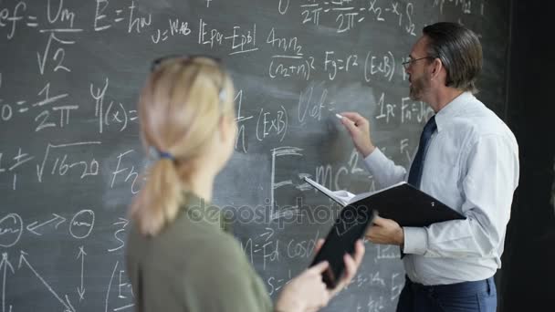 Mujer Sonriente Retrato Con Tableta Hombre Escribiendo Fórmulas Matemáticas Pizarra — Vídeos de Stock