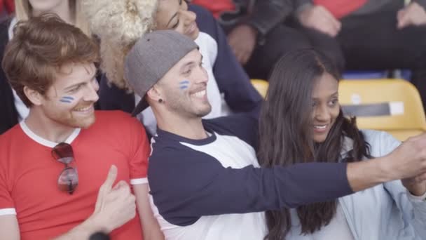 Vrienden Zitten Menigte Sport Evenement Possing Voor Selfie Met Telefoon — Stockvideo