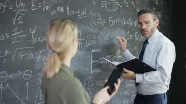 4k tablet ve matematik formülleri tahtaya yazma adam gülümseyen kadın portre