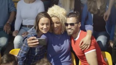 spor olay possing için selfie telefon ile kalabalık oturan 4 k arkadaşlar