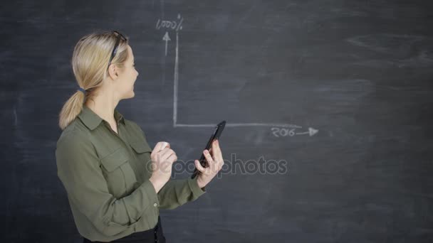 使用计算机平板电脑的妇女和绘制黑板上的商业成功图 — 图库视频影像