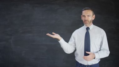 doğrudan kameraya konuşurken ve boş yazı tahtası arka plana işaret 4k dostum