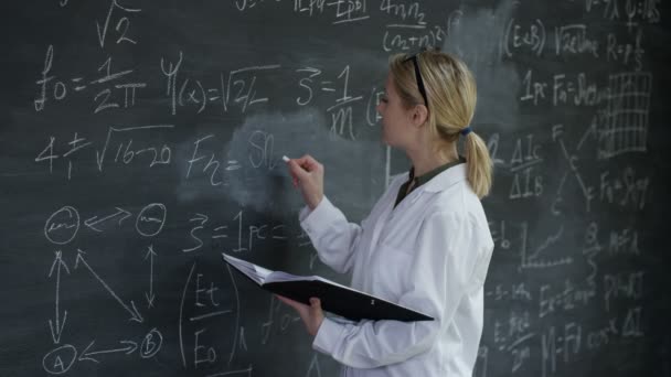 Frau Weißen Mantel Schreibt Mathematische Formeln Auf Die Tafel — Stockvideo