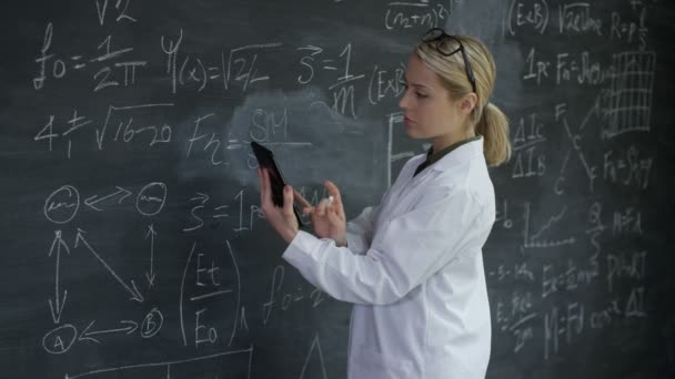 Stående Leende Kvinna Med Tablett Skriva Matematiska Formler Blackboard — Stockvideo