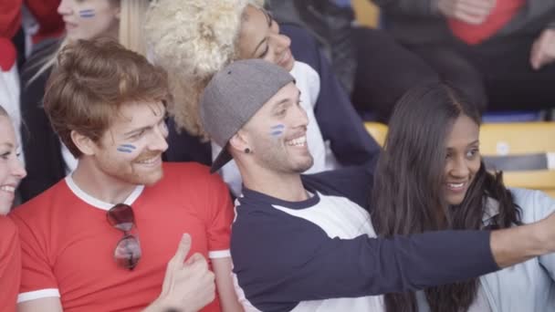 Vrienden Zitten Menigte Sport Evenement Possing Voor Selfie Met Telefoon — Stockvideo