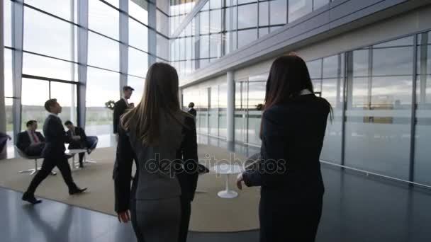 Imprenditrici Che Parlano Mentre Camminano Attraverso Moderno Edificio Uffici Vetro — Video Stock