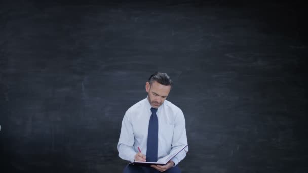 Hombre Escribiendo Libro Buscando Inspiración Fondo Pizarra Blanco — Vídeos de Stock