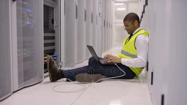 ストレス チェック データ センター内サーバ エンジニアの床に座って ノート パソコンに取り組んで — ストック動画