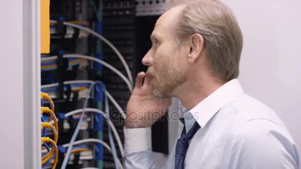 Комп Ютерний Інженер Працює Ноутбуці Розмовляє Телефону Перевіряючи Сервери Центрі — стокове відео