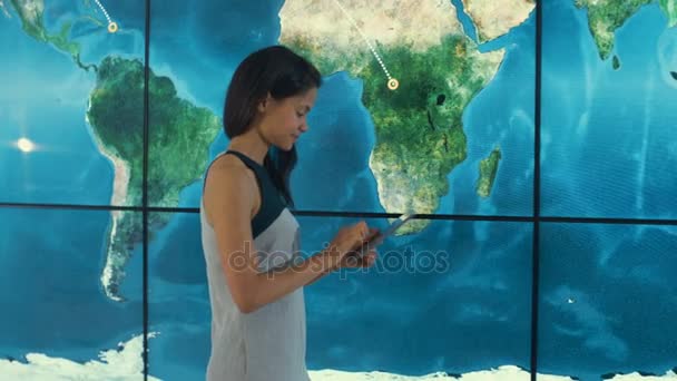 Businesswoman Con Tableta Mirando Gráfico Grande Del Mapa Del Mundo — Vídeos de Stock