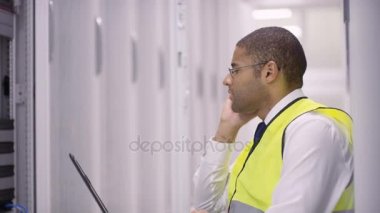 Sunucular içinde bir veri merkezi kontrol üstünde laptop çalışma ve Evet, bilgisayar mühendisi.