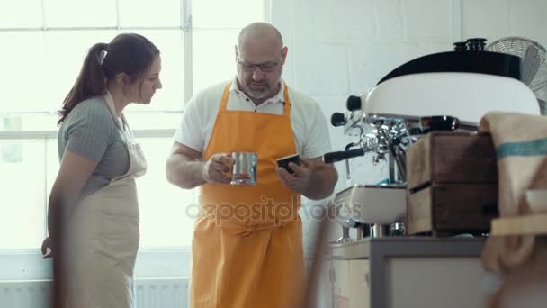 4k-Café-Unternehmer schult Mitarbeiter im Umgang mit der Kaffeemaschine
