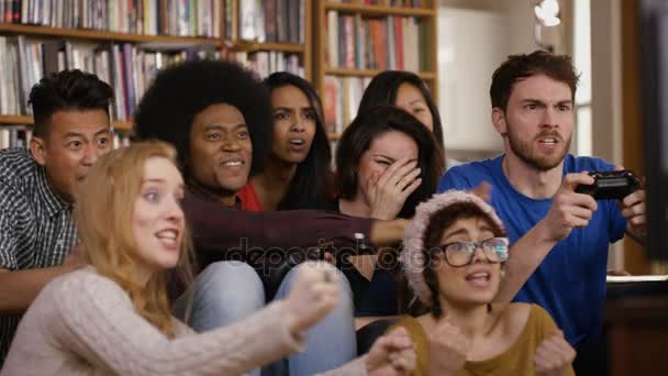 Большая Группа Счастливых Молодых Друзей Тусующихся Дома Играющих Видеоигры — стоковое видео