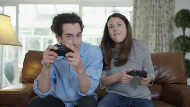 競争力のあるカップルの自宅一緒にビデオゲームを遊ぶこと — ストック動画