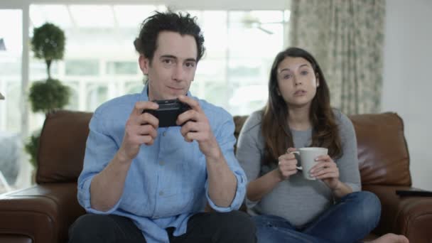 Конкурентный Мужчина Играет Видеоигры Дома Скучающей Беременной Женой — стоковое видео