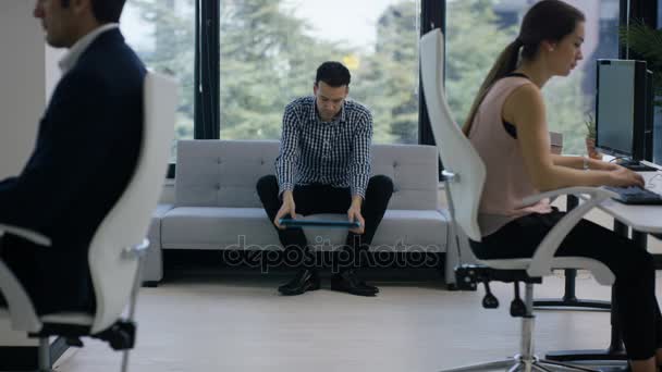 近代的なオフィス 休憩のため横になっている男を中心に ビジネス チーム — ストック動画
