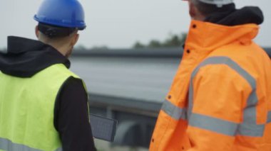 Güneş enerjisi tesisi işlemleri tartışırken bilgisayar tablet ile 4 k teknisyenleri