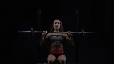 4k genç kadın ağırlık terbiye, oturur pozisyonda halter kaldırma uygun