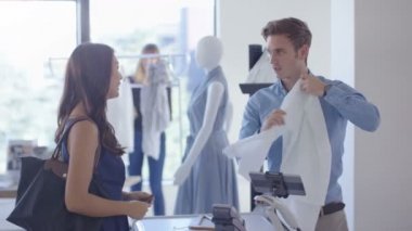 Kadın giyim mağazasında alışveriş smartphone ile temassız ödeme yapar.