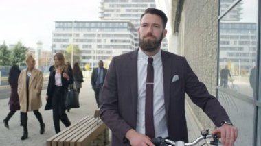 4 k sakallı işadamı şehirde yürüyüş bisiklet ile