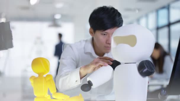 Ingénieur en électronique asiatique 4K travaillant en laboratoire avec un prototype de robot 