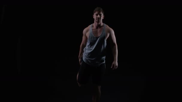 Fit Pemuda Dengan Fisik Otot Peregangan Terhadap Latar Belakang Hitam — Stok Video
