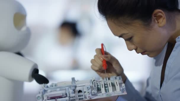 Équipe de conception technique 4K travaillant sur la construction d'un robot dans un laboratoire moderne 