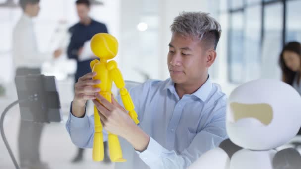 Ingénieur en électronique asiatique 4K travaillant en laboratoire avec un prototype de robot 