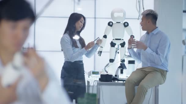 Équipe de conception technique 4K travaillant sur la construction d'un robot dans un laboratoire moderne 