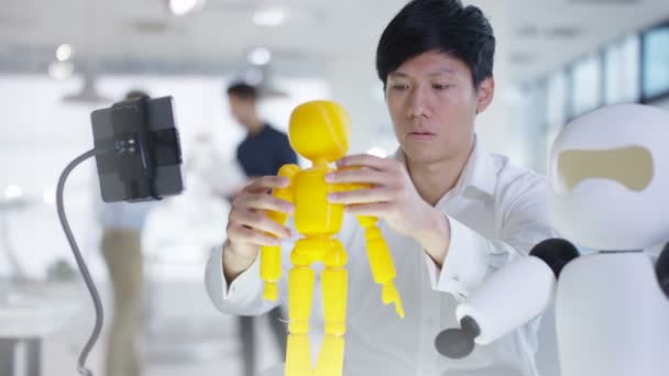 Ingénieur en électronique asiatique 4K travaillant en laboratoire avec un prototype de robot 