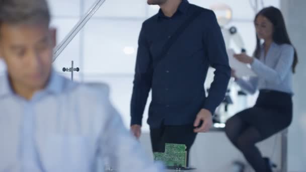 Équipe de conception technique 4K collaborant à la construction d'un robot dans un laboratoire moderne 