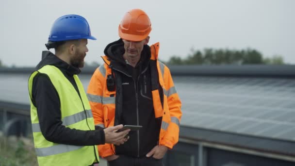 Técnicos Con Tableta Computadora Discutiendo Operaciones Planta Energía Solar — Vídeo de stock