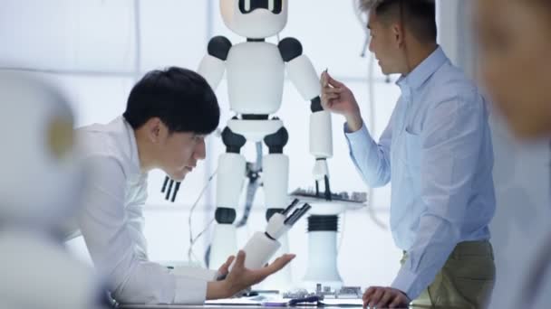 Équipe de conception technique 4K travaillant sur la construction d'un robot dans un laboratoire moderne 