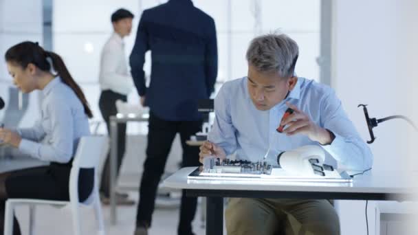 Équipe de conception technique 4K travaillant sur la construction d'un robot dans un laboratoire moderne 