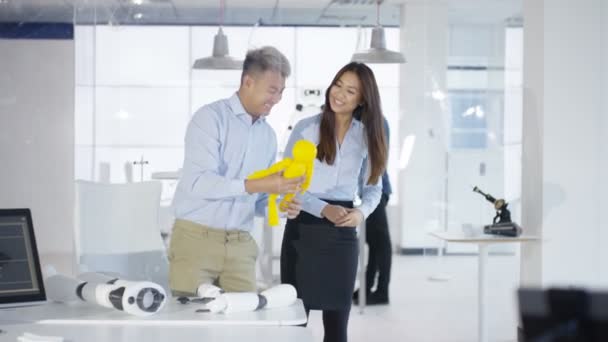 Ingénieurs en électronique asiatiques 4K travaillant en laboratoire avec un prototype de robot 