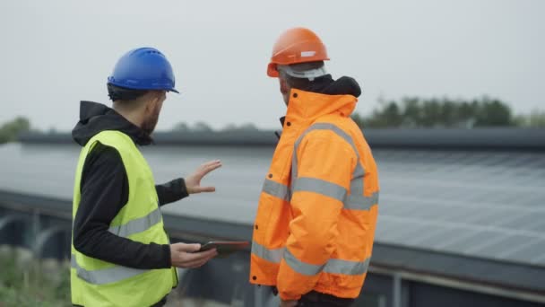 Técnicos Con Tableta Computadora Discutiendo Operaciones Planta Energía Solar — Vídeo de stock