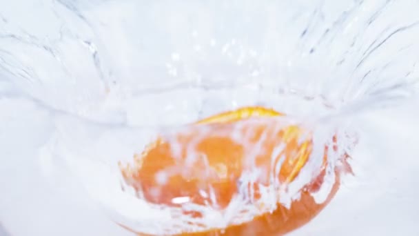 切割新鲜的橙色下降到清澈的纯净水 关闭在慢动作 — 图库视频影像