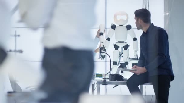 Ingénieurs techniques 4K travaillant sur la construction d'un robot automatisé dans un laboratoire moderne .