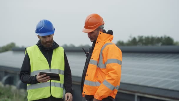 Techniciens Avec Tablette Informatique Discutant Des Opérations Centrale Solaire — Video