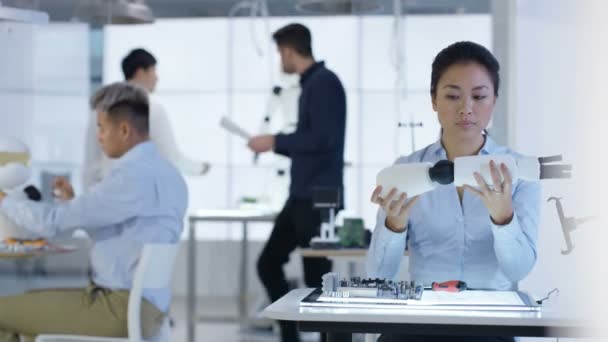 Équipe de conception technique 4K travaillant sur la construction d'un robot dans un laboratoire moderne 