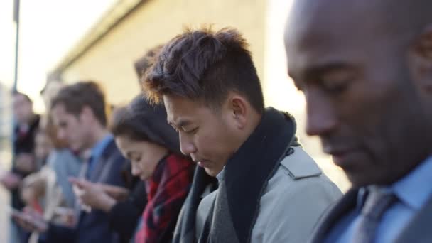 Diverse Unternehmensgruppe Schaut Auf Smartphones Während Sie Der Schlange Steht — Stockvideo