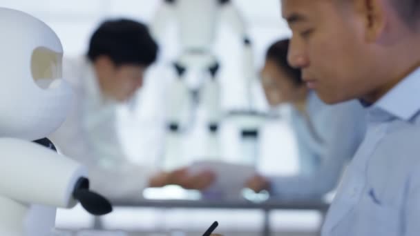 Équipe de conception technique 4K travaillant sur la construction d'un robot dans un laboratoire moderne 