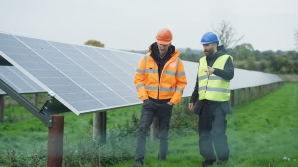 在太阳能工厂工作的技术人员 检查面板和谈话 — 图库视频影像