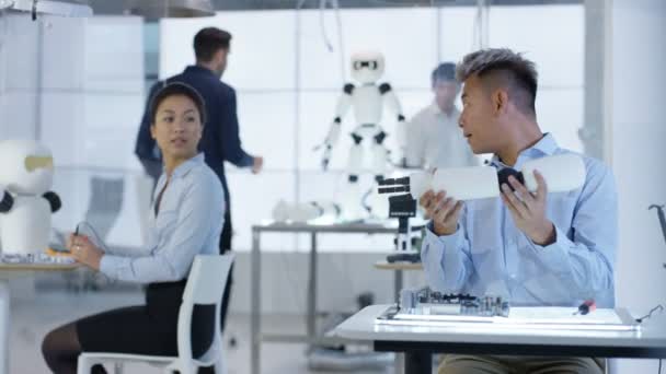 Équipe de conception technique 4K travaillant sur la construction d'un robot dans un laboratoire moderne 